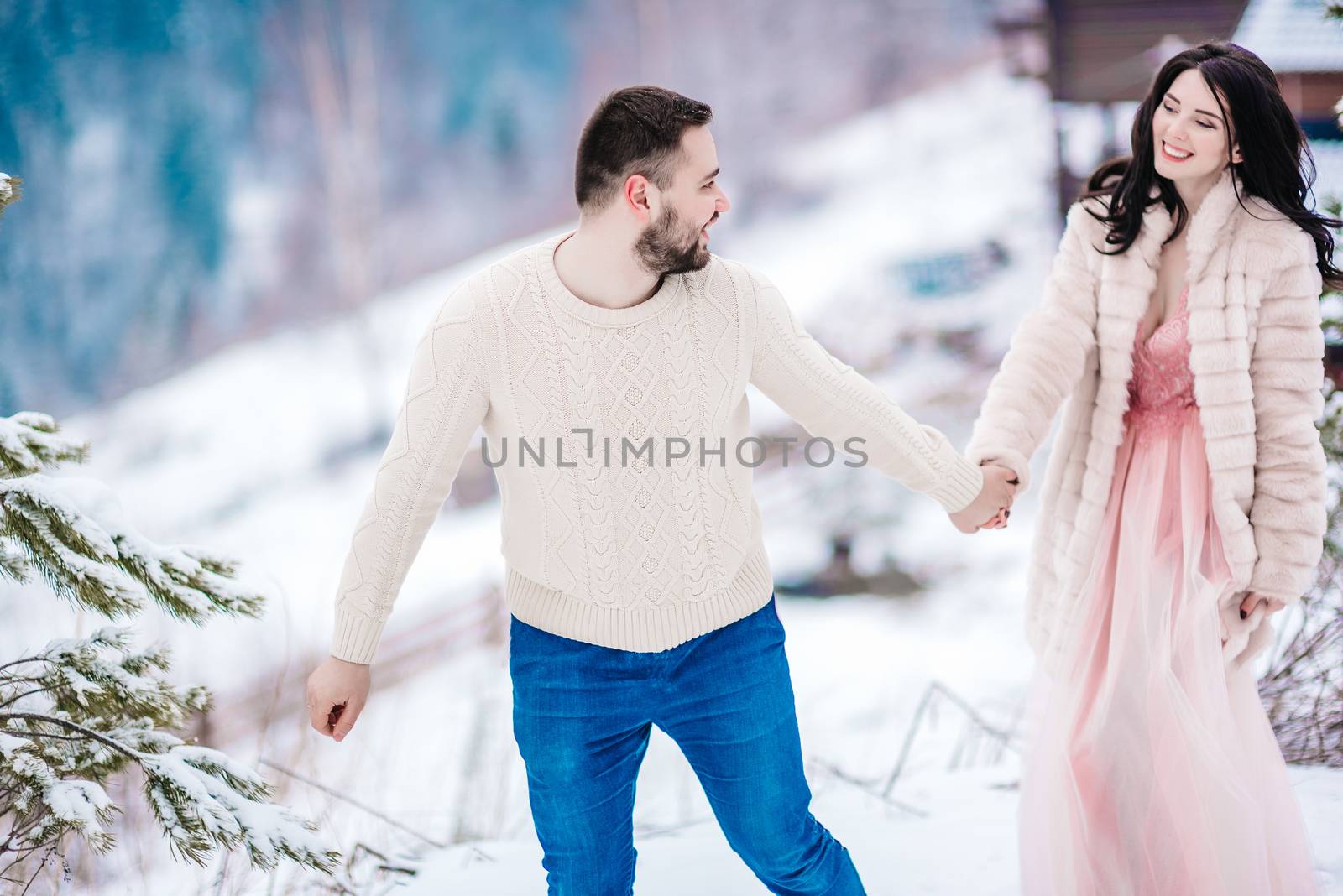 young couple on a walk in the snowy mountains by Andreua