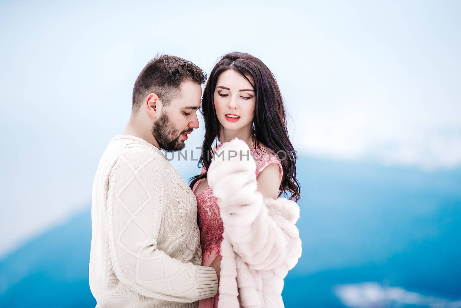 a bride in a fur coat with a fiance among the Carpathian mountains