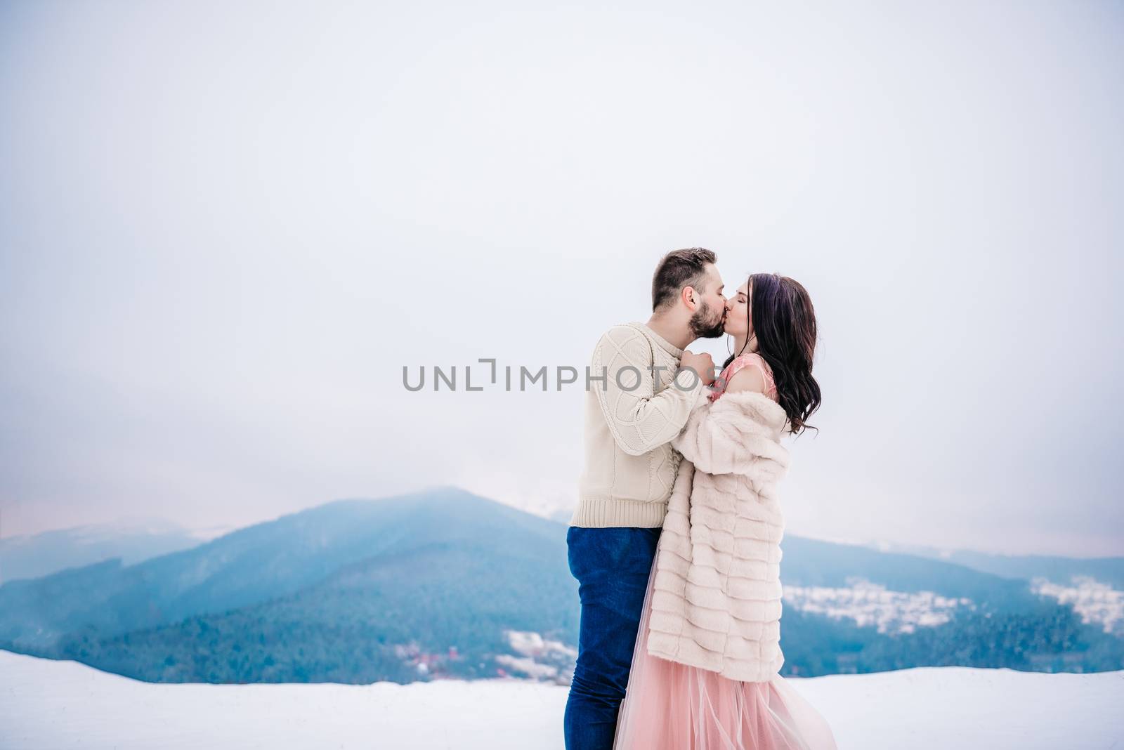 a bride in a fur coat with a fiance among the Carpathian mountains