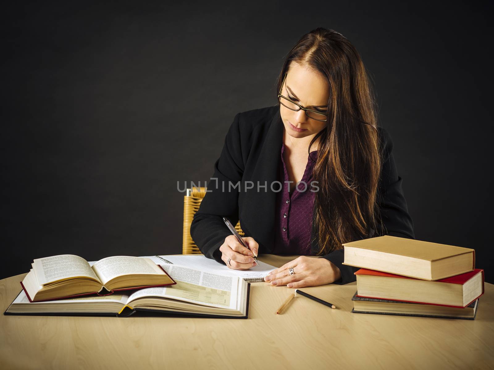 Attractive teacher sitting at her desk writing by sumners