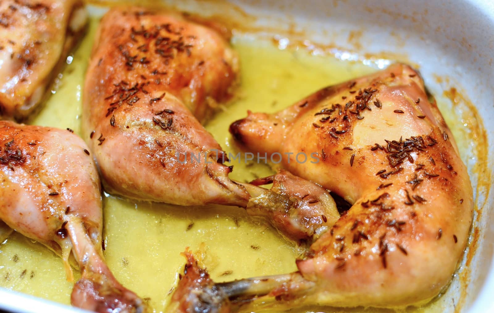 Close Up of a Roasted Chicken Drumsticks in a Roasting Pan.
