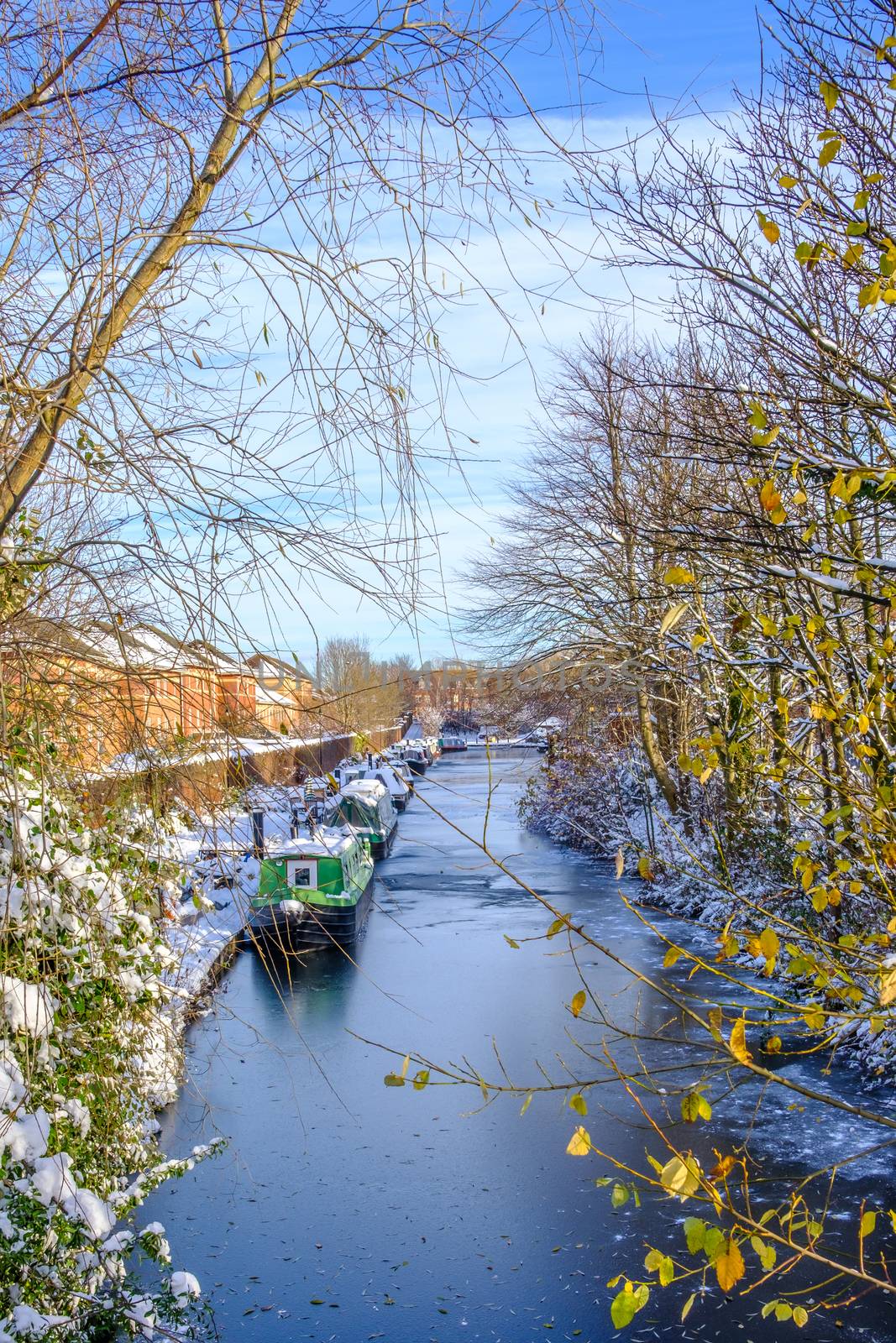 Snow covered canal boats seen in frozen Birmingham canal.