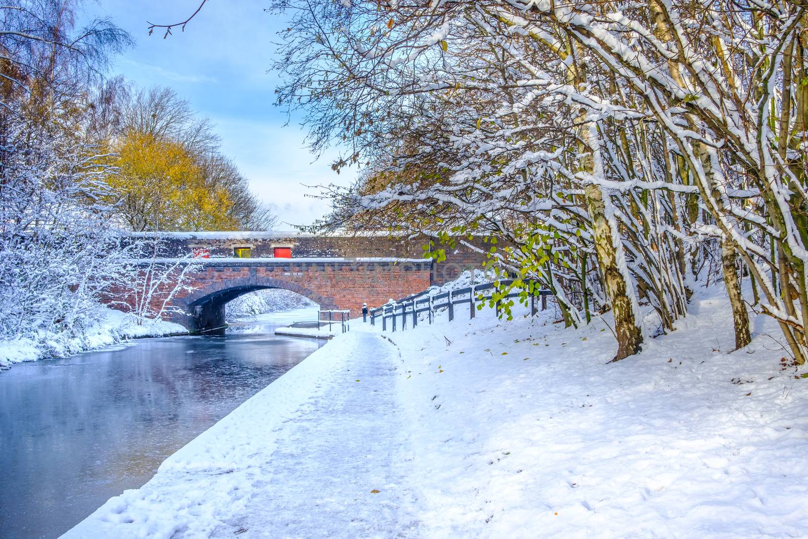 View of frozen Birmingham Canal and a bridge made of bricks