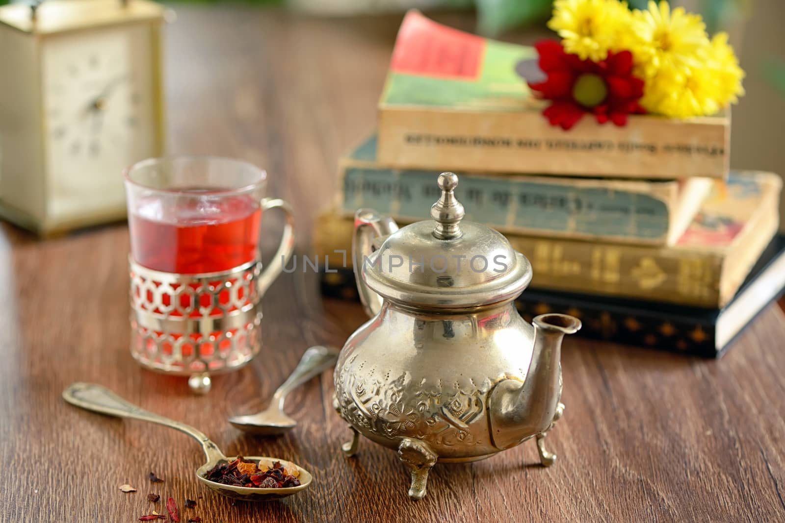 Tea cup and old fashioned silver teapot on wooden table
