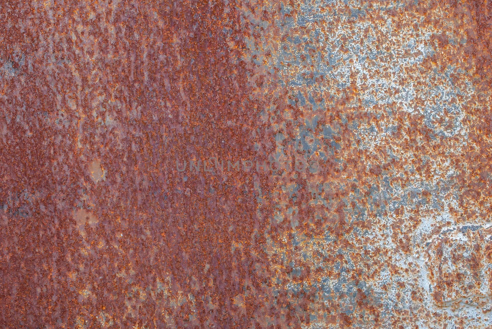 rusty iron surface covered with old chipped paint, which has long been influenced by different climatic conditions
