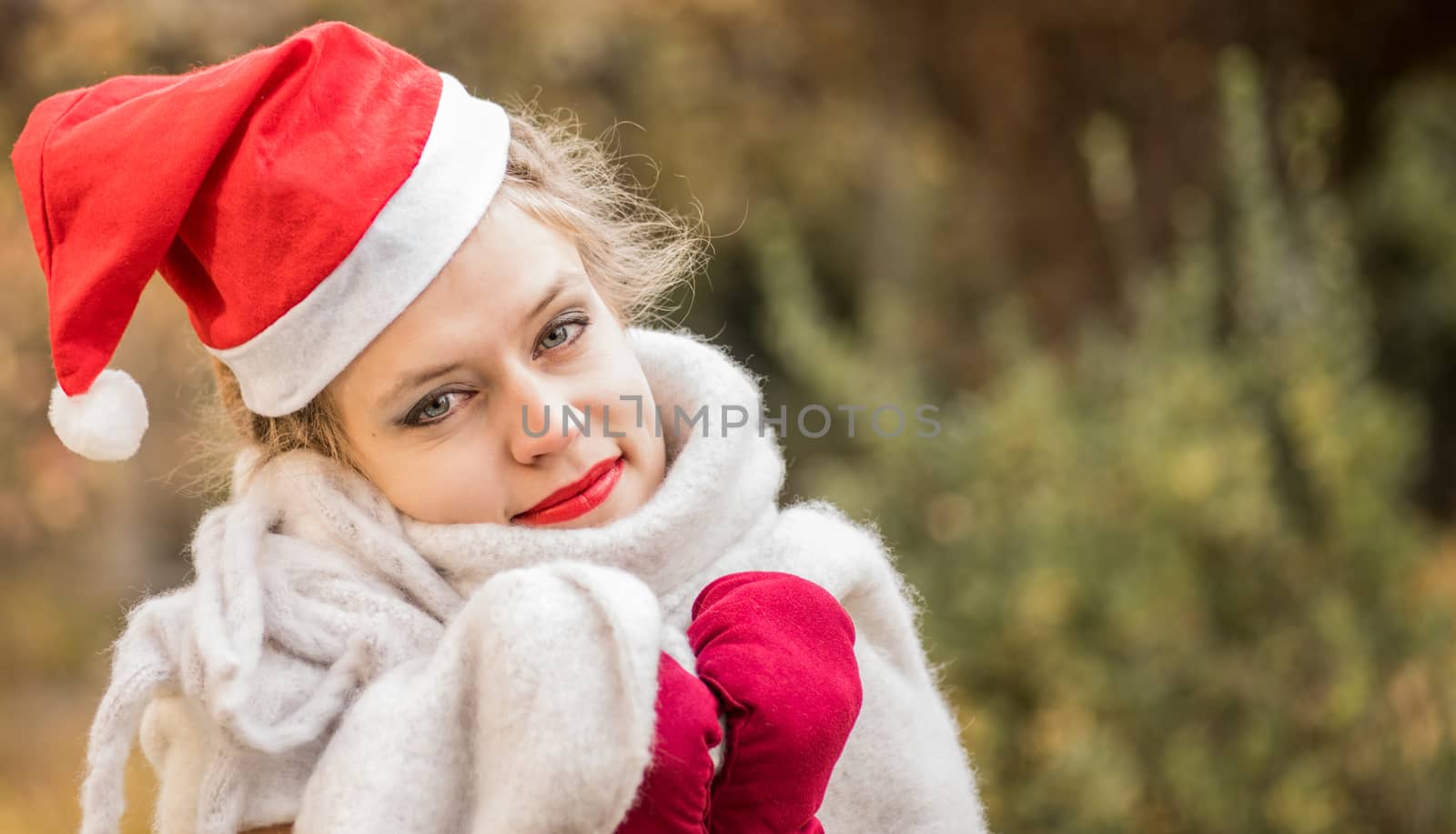 christmas concept. european woman wearing warm clothes and christmas hat outdoors