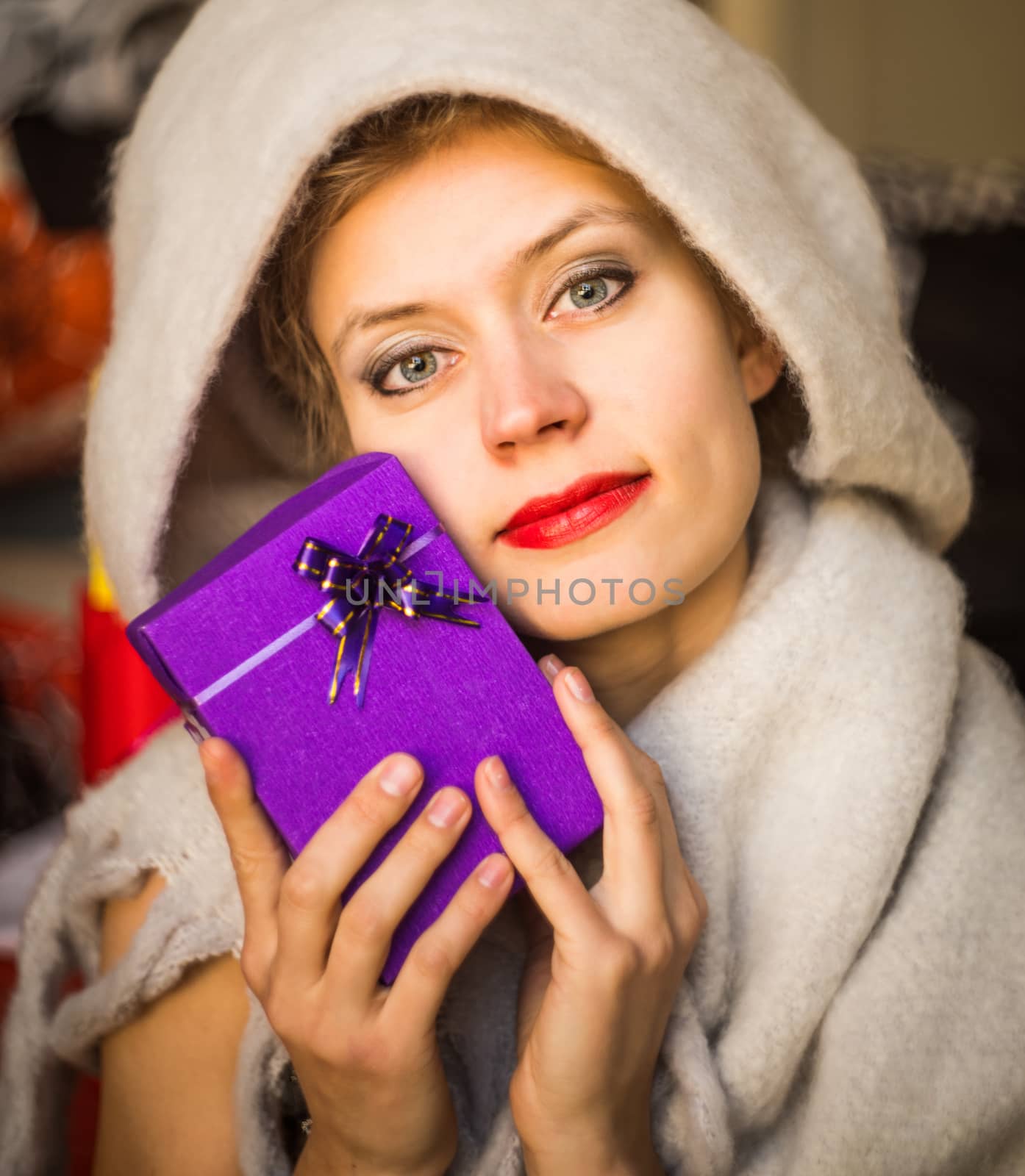 young caucasian womanis holding a gift in her hands. woman celebrating holiday with present