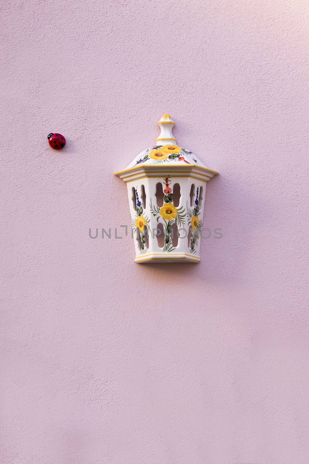 Street light ceramic cover and ladybird insect in the wall.