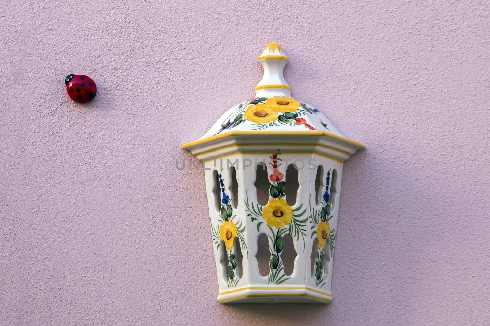 Street light ceramic cover and ladybird insect in the wall.