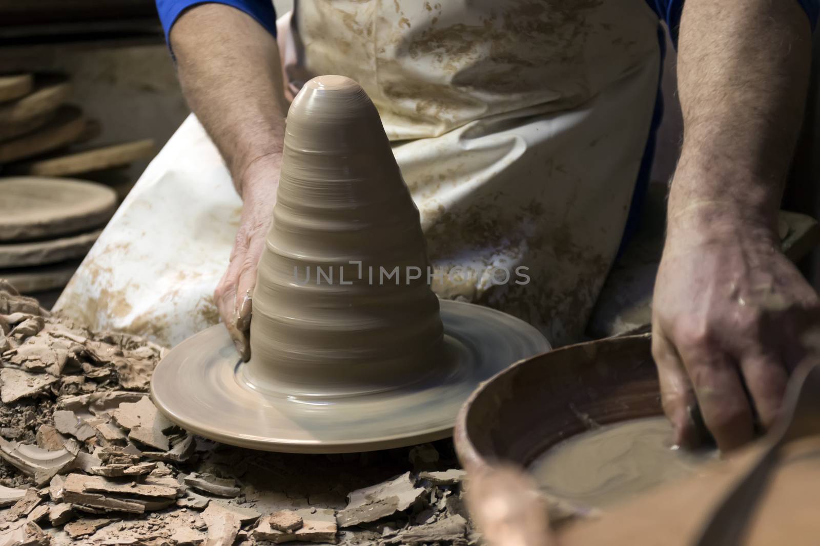 Close up view of the hands of ceramic artist making a piece from clay.
