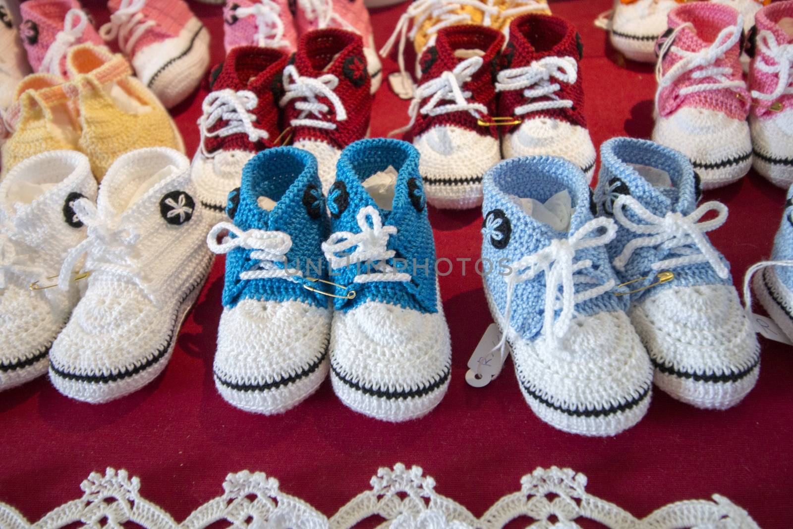 Varied mix of colorful knitted baby shoes.