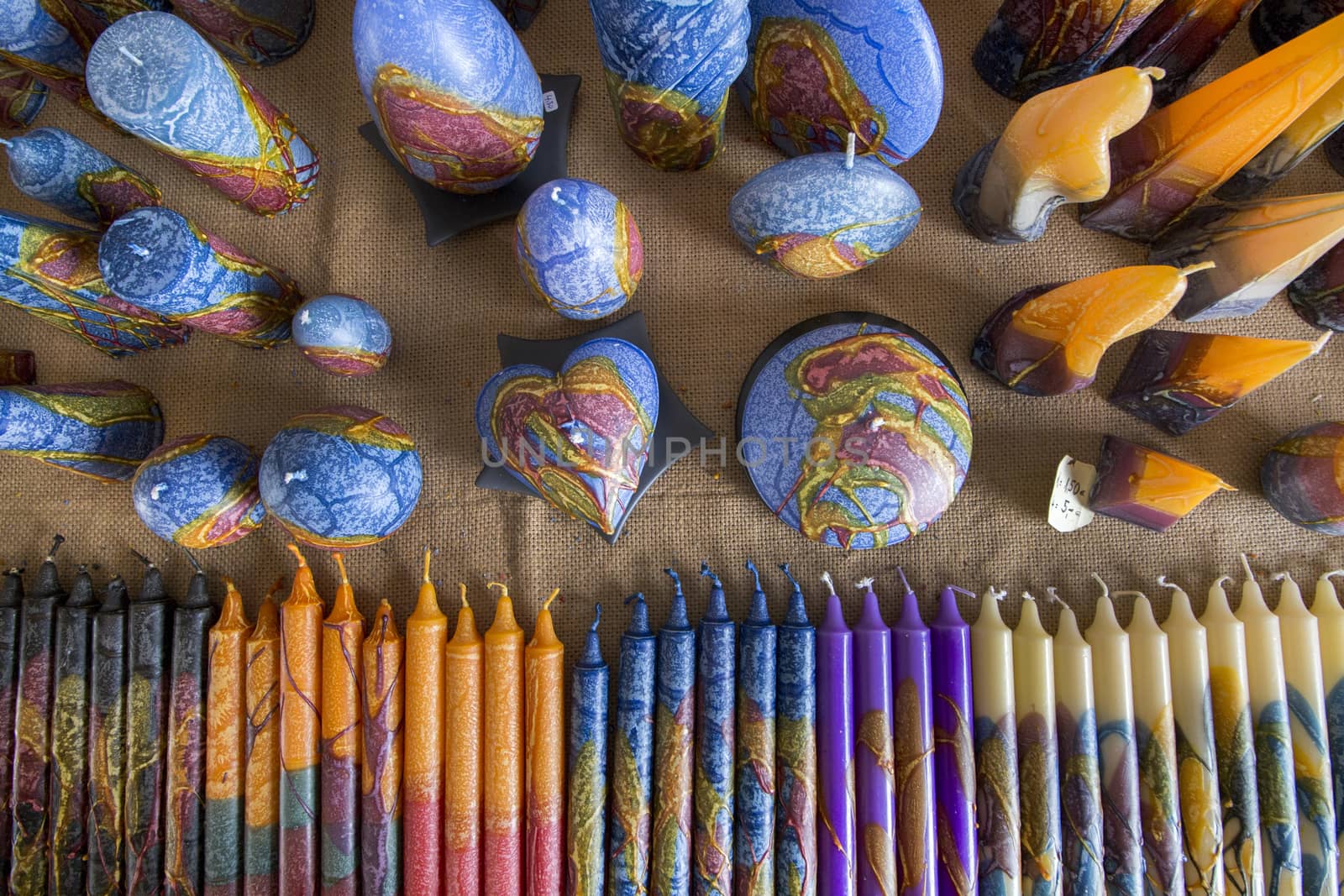 View of several handmade candles in tones of blue, yellow and other colors.