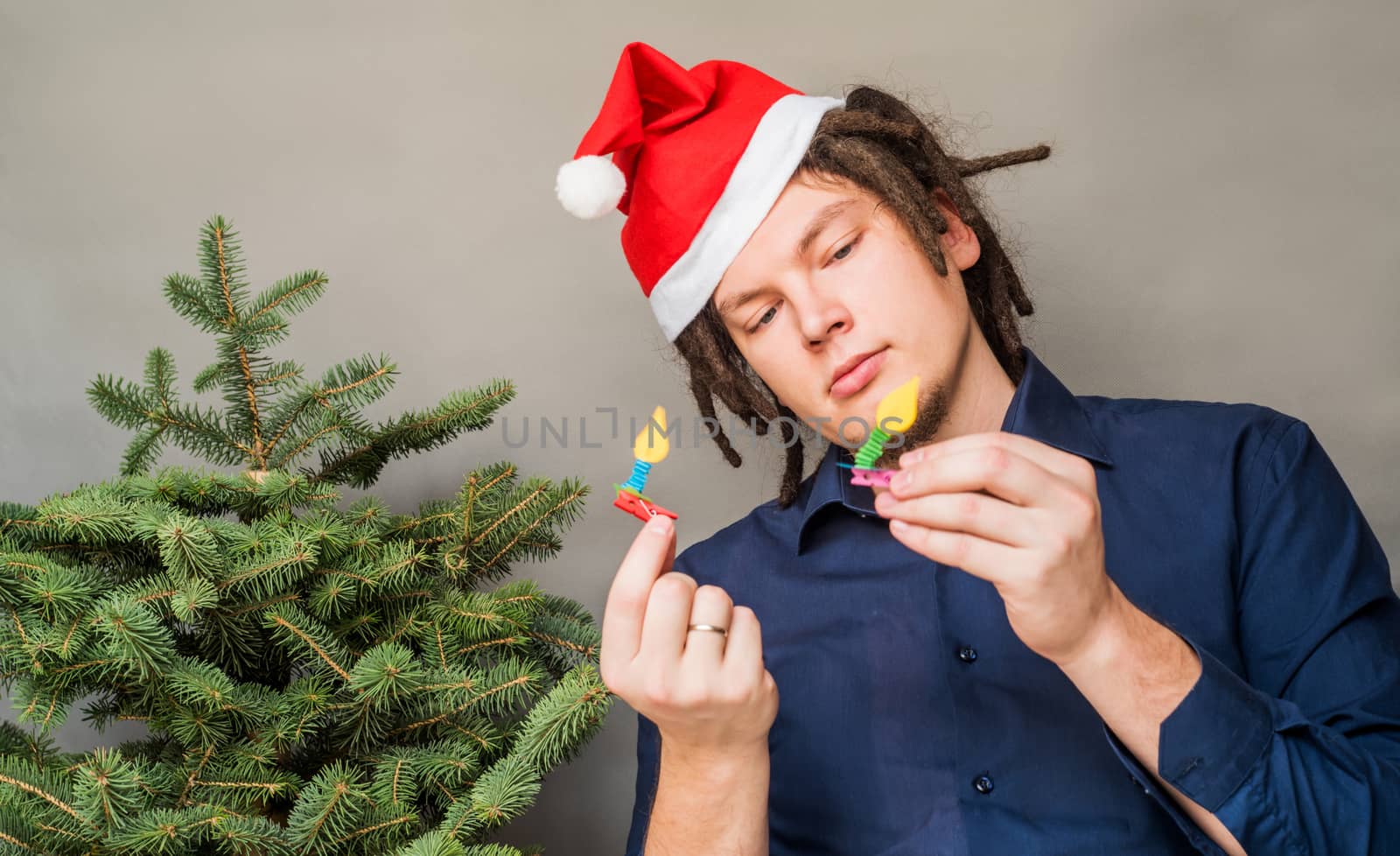 young caucasian man with afro hair looking at christmas decorations. christmas concept