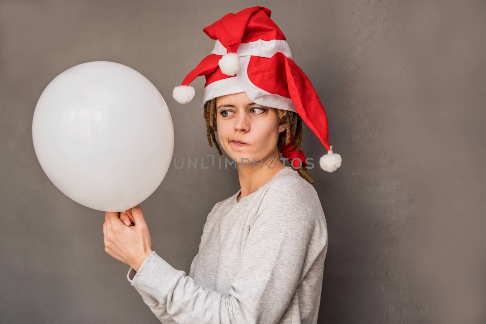 christmas young woman holding a balloon watching with doubt by Desperada