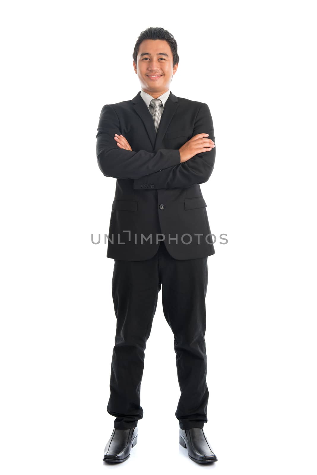 Full body arm crossed young Southeast Asian businessman standing isolated on white background. 