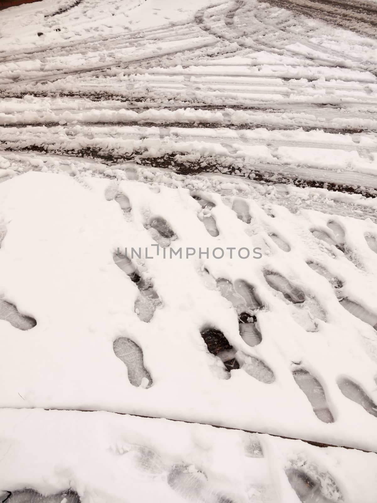snow on path and road outside tire marks trails foot prints floor background; essex; england; uk