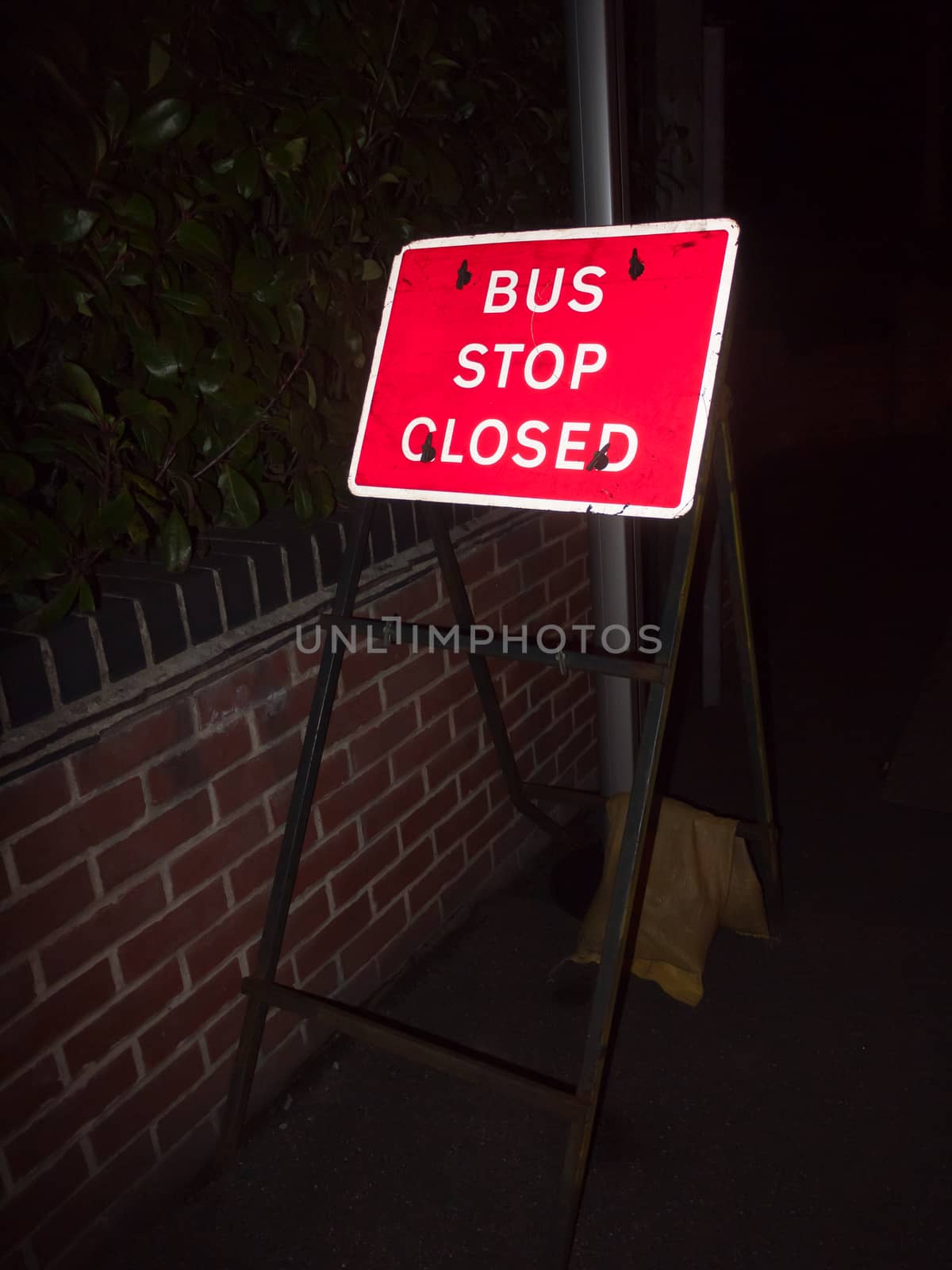 red road sign at night bus stop closed; essex; england; uk