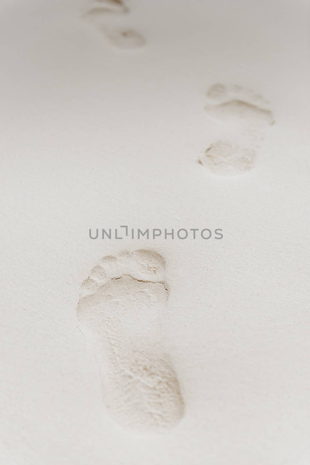 close-up of footprints on white sand on a desert island