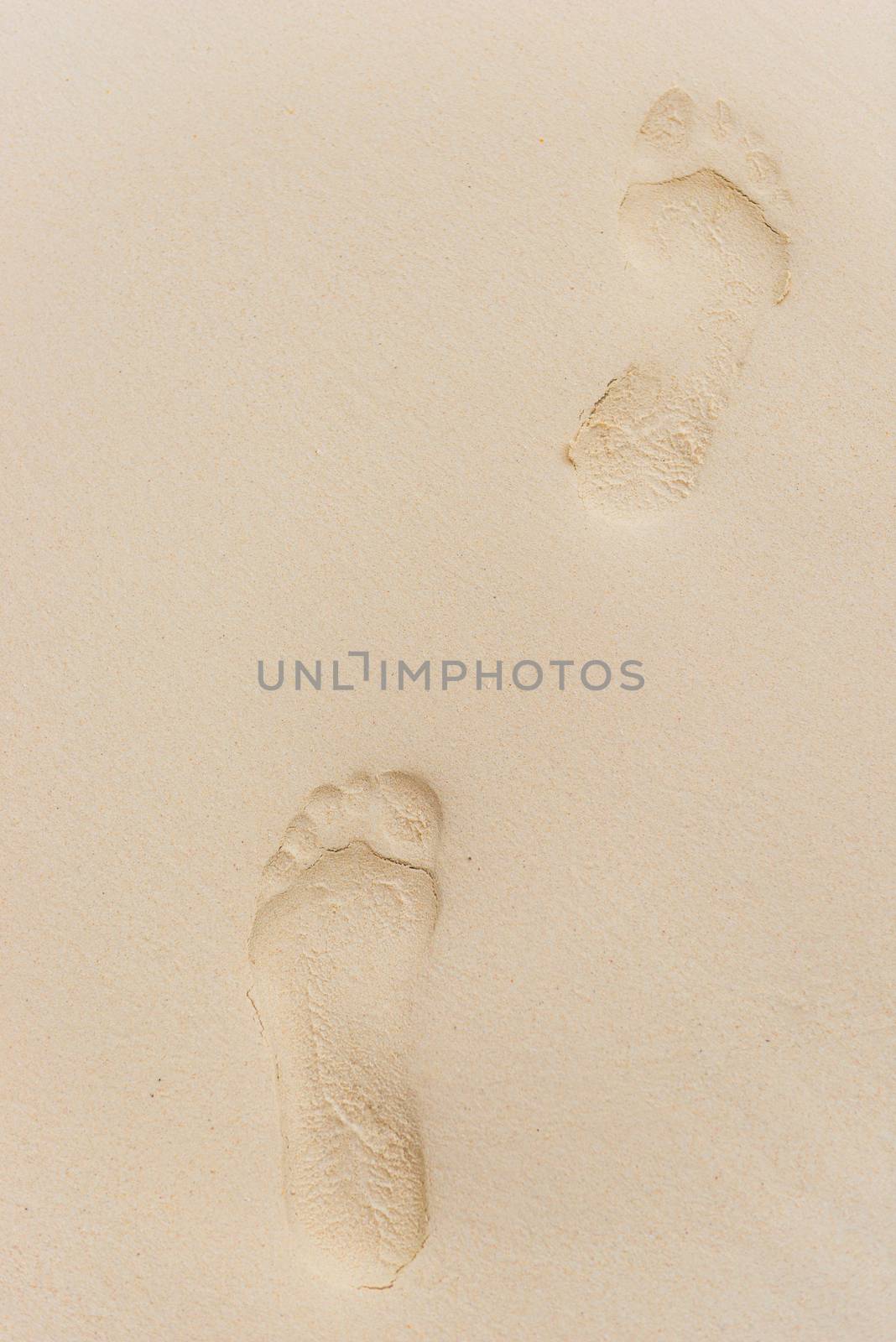 top view of footprints on wet sand close up by kosmsos111