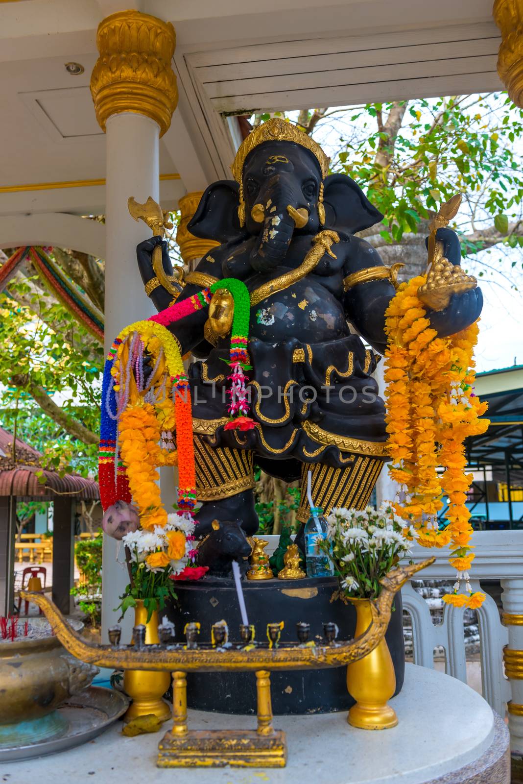 sculpture of Ganesha God with flowers close-up on the street by kosmsos111