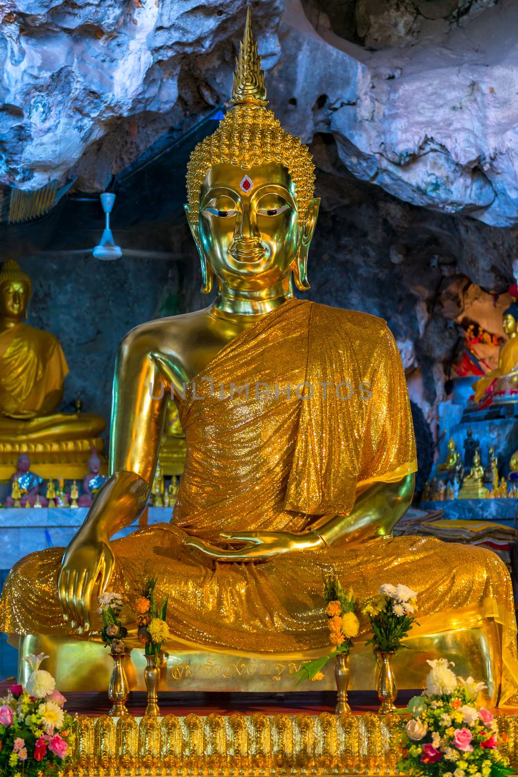 god Buddha in gold clothes gold sculpture in the cave of the tiger in Thailand, Krabi
