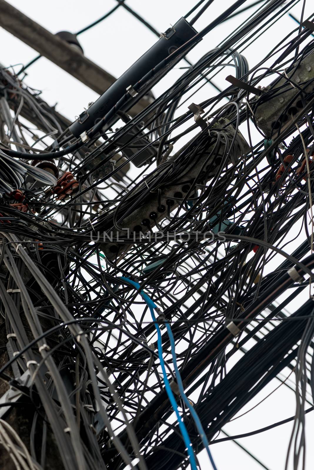 Photo closeup randomly hanging wires on electric poles in Thailand