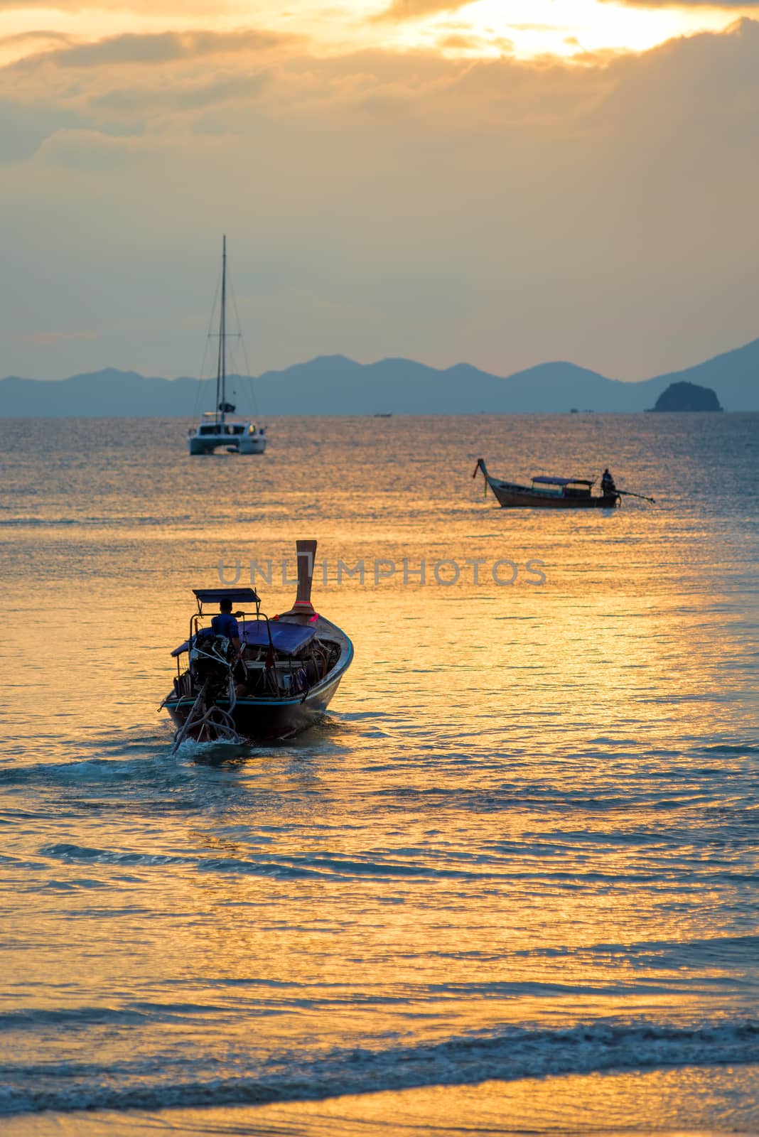 Thai wooden boats in the rays of the setting sun vertical photog by kosmsos111