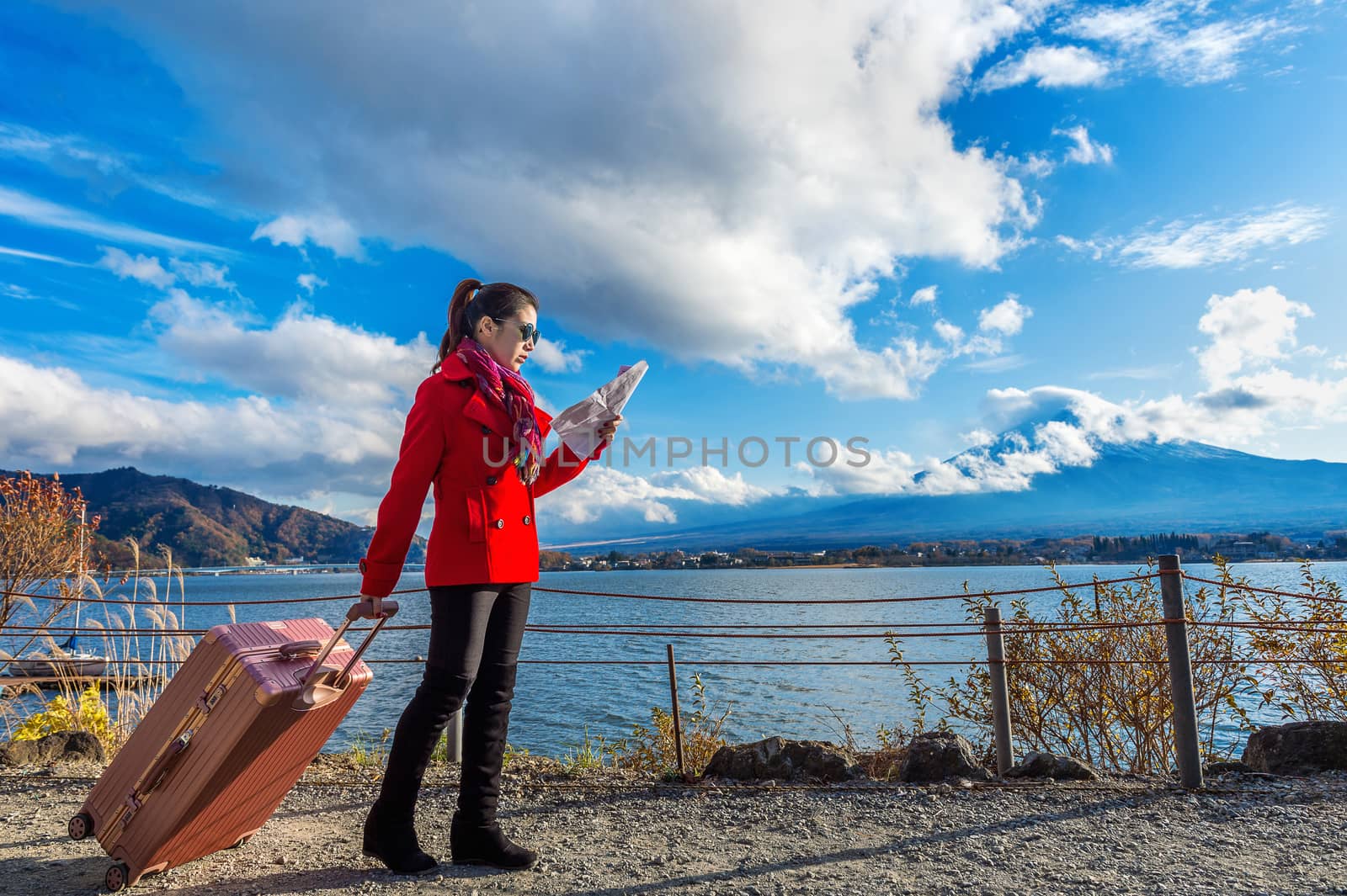 Tourist with baggage and map at Fuji mountain, Kawaguchiko in Japan.