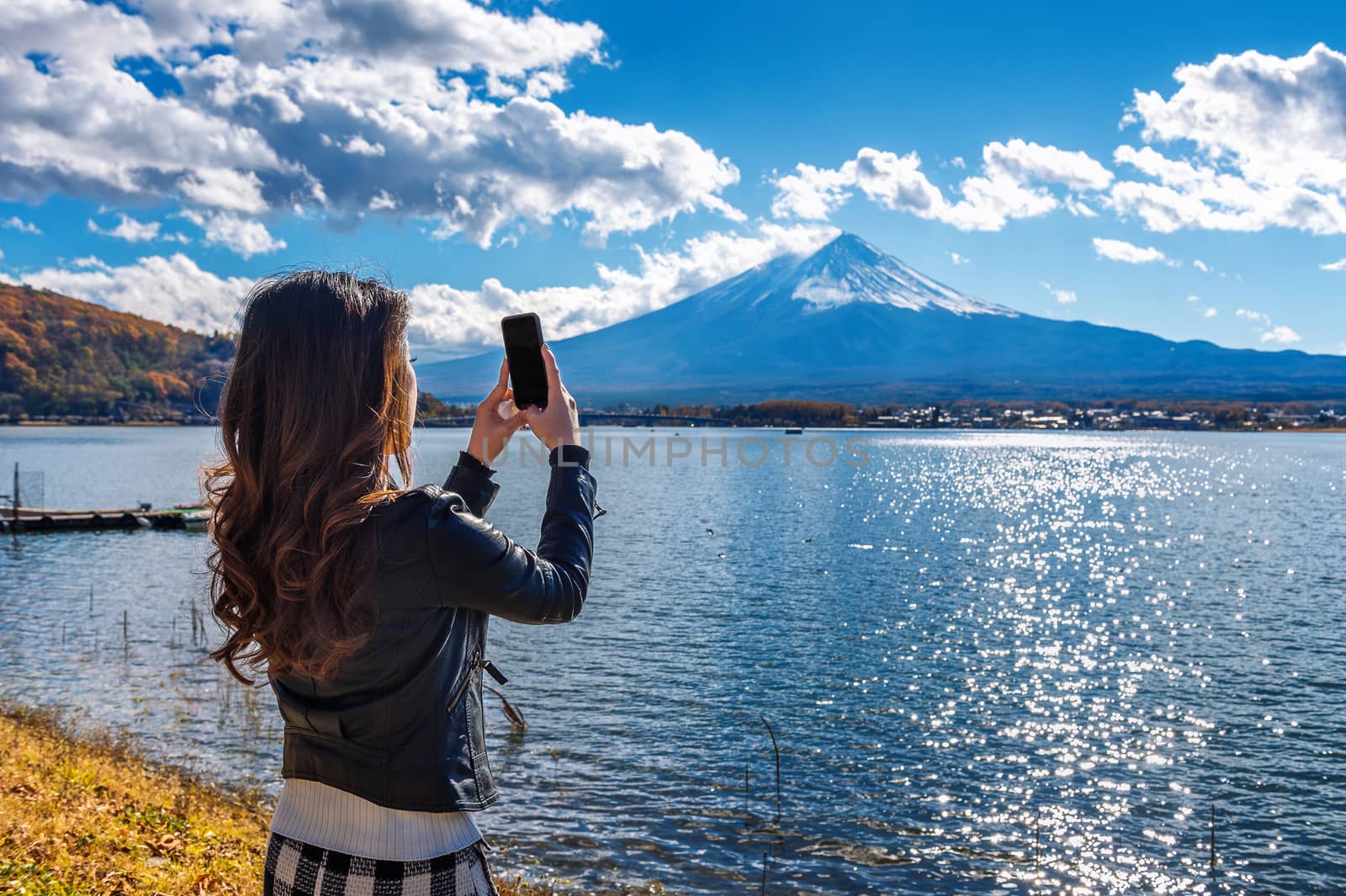 Woman use mobile phone take a photo at Fuji mountains, Kawaguchiko lake in Japan. by gutarphotoghaphy