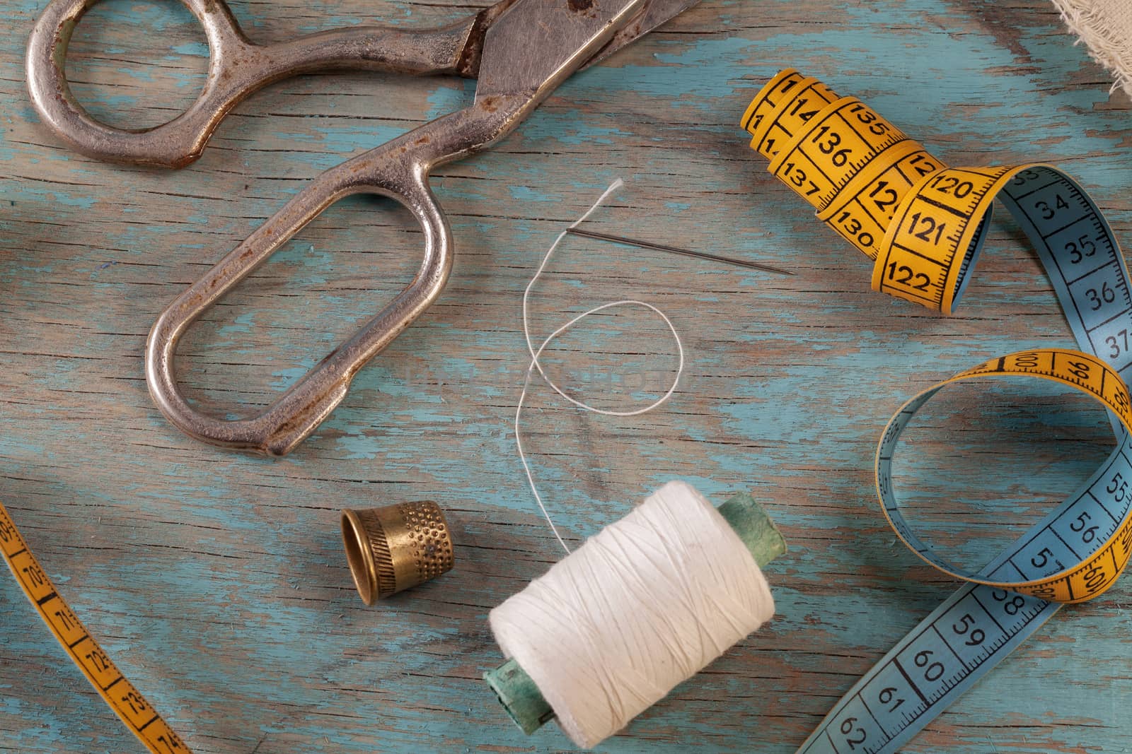 Retro sewing accessories on blue wooden background by igor_stramyk