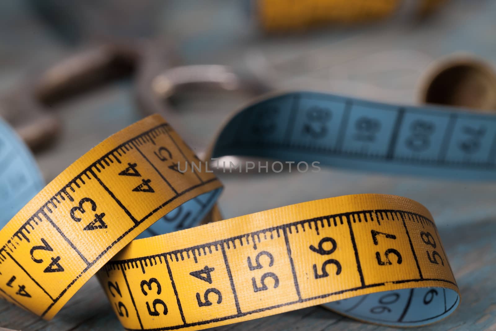 Retro sewing accessories - tape measure and threads on blue background