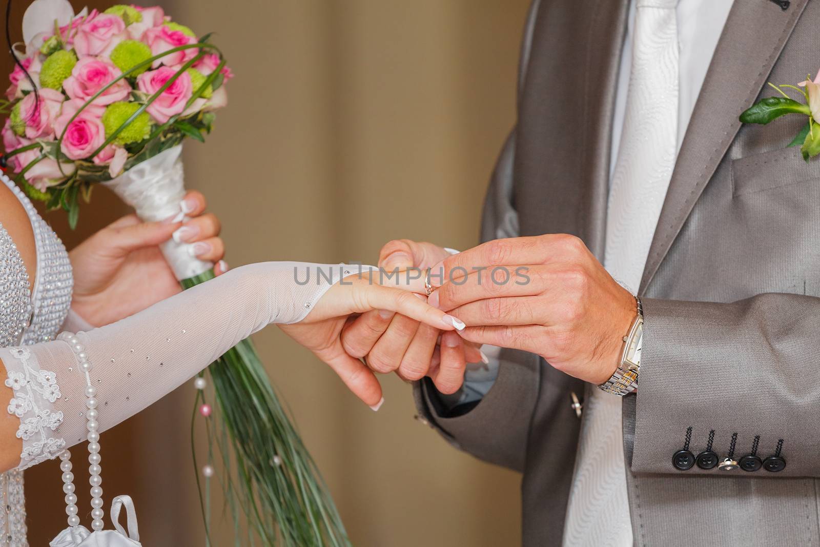 The groom has put on an engagement ring on a finger of the bride by fogen