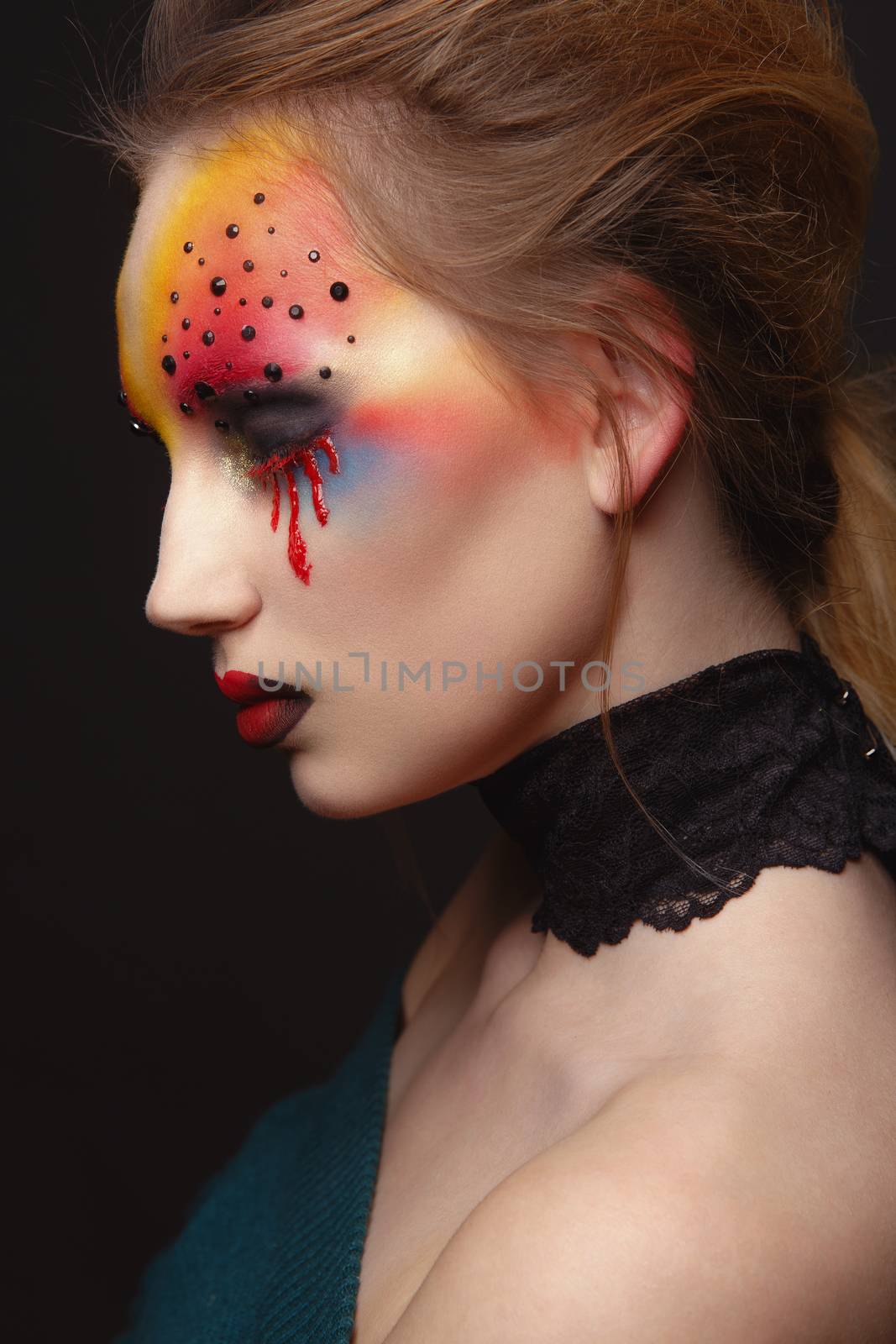 Portrait of young and beauty female model with creative makeup, bloody eyes and black rhinestones