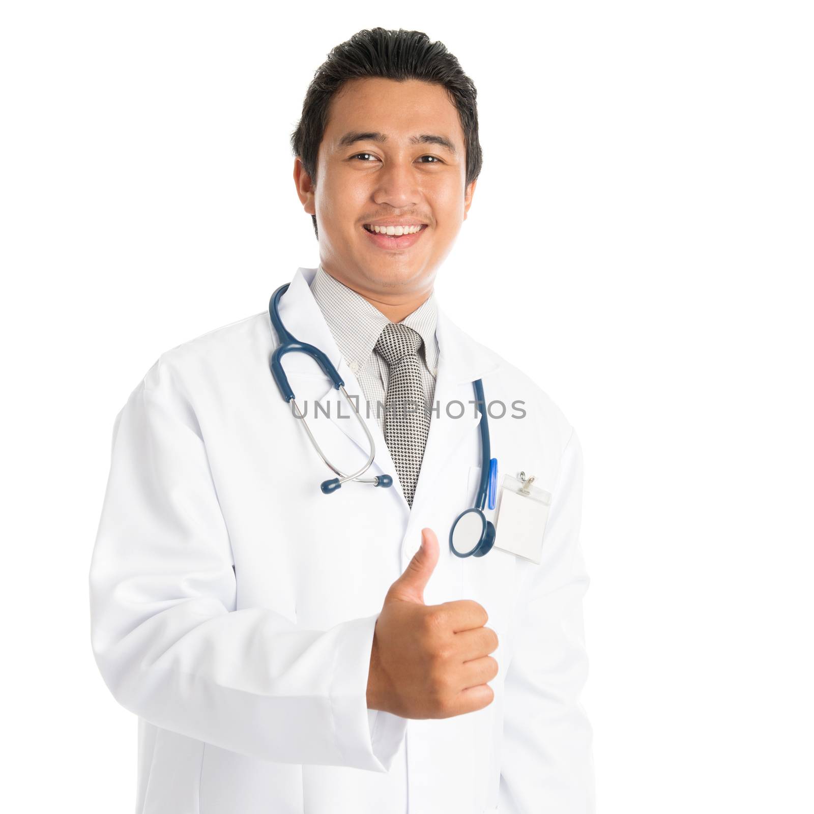 Portrait of attractive young male Southeast Asian medical doctor giving thumb up, standing isolated on white background.