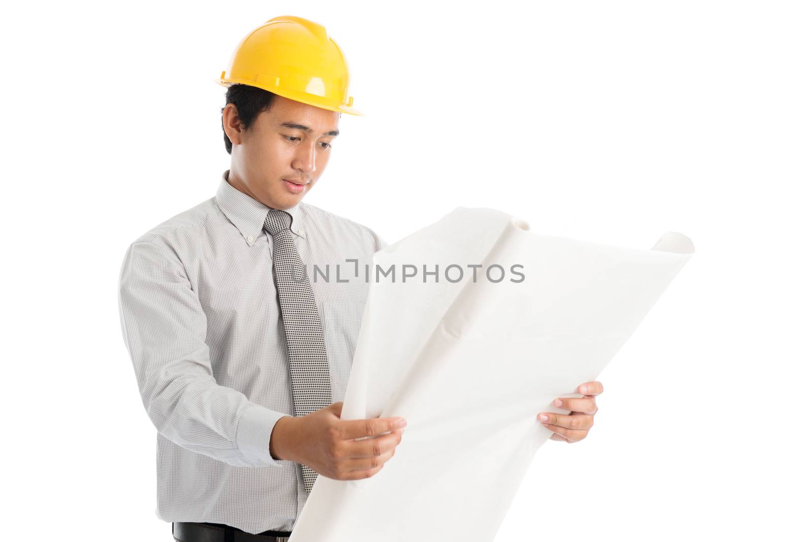 Portrait of attractive Southeast Asian engineer with yellow hard hat and blue prints, standing isolated on white background.