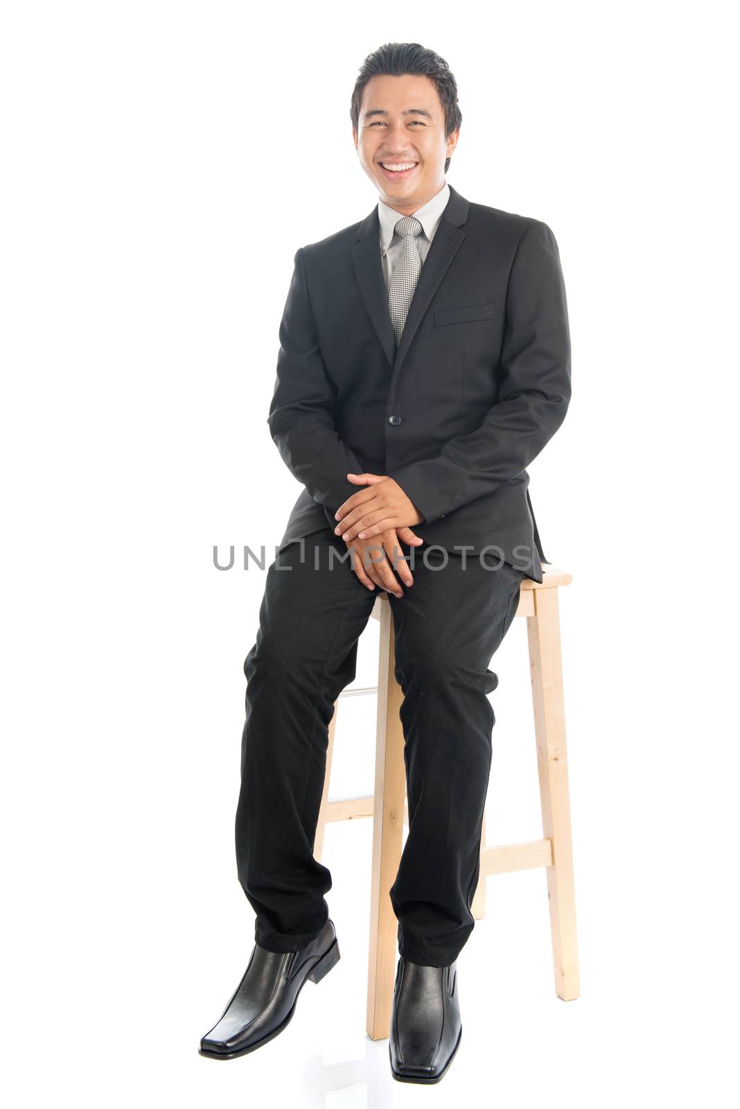 Full body Asian businessman sitting on chair by szefei