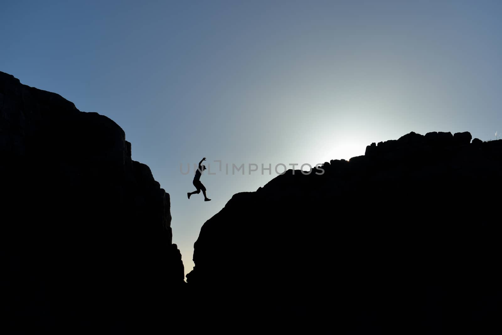 man who jumped on the rocks in silhouette by crazymedia007