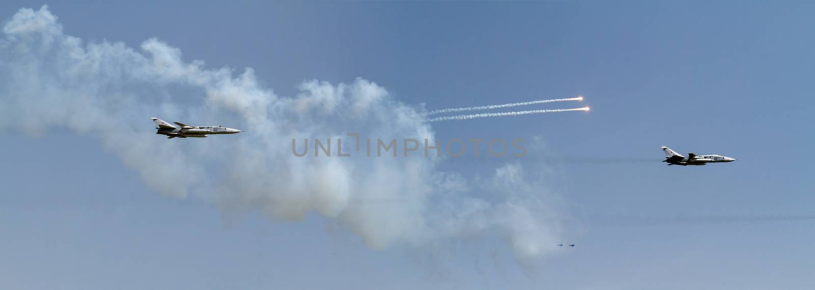 Two military aircrafts flying in the blue sky by fogen