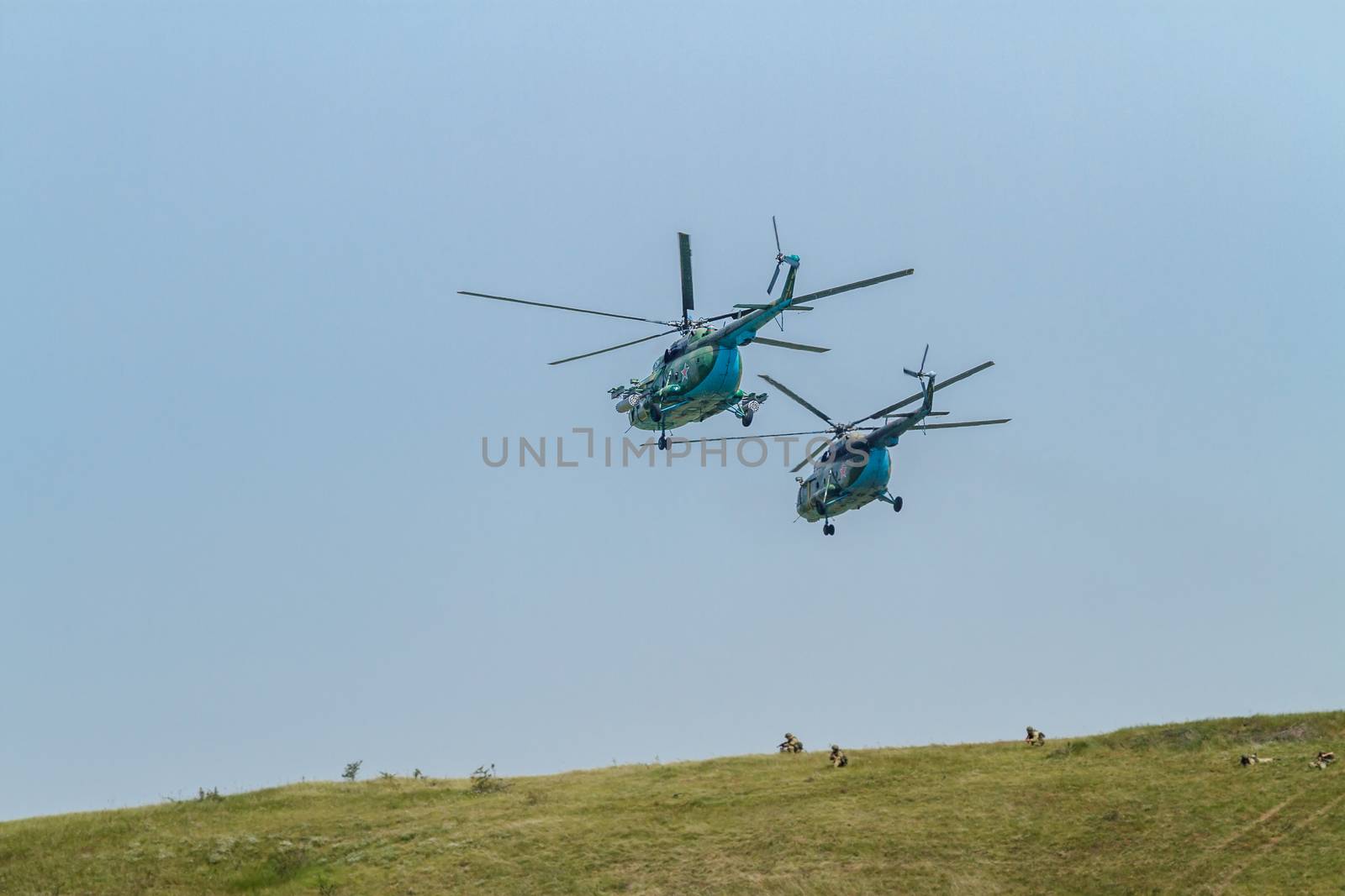 Two military helicopters on maneuvers, protect troops