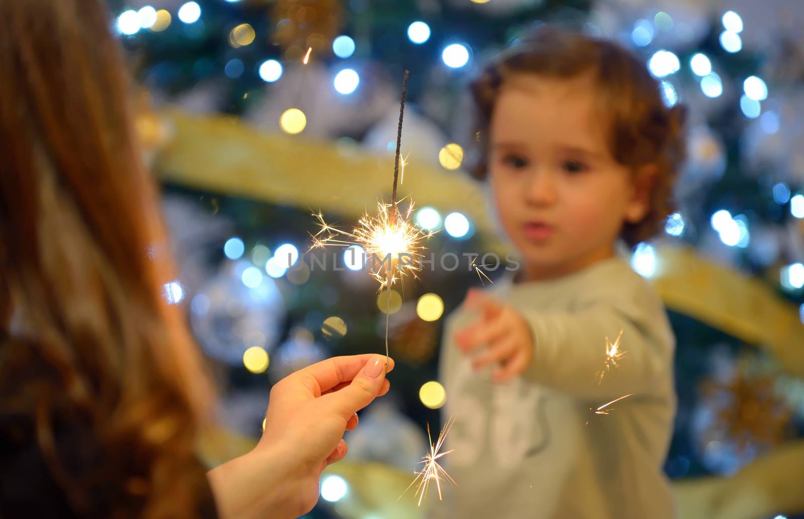 Teen girl holding sparklers and children