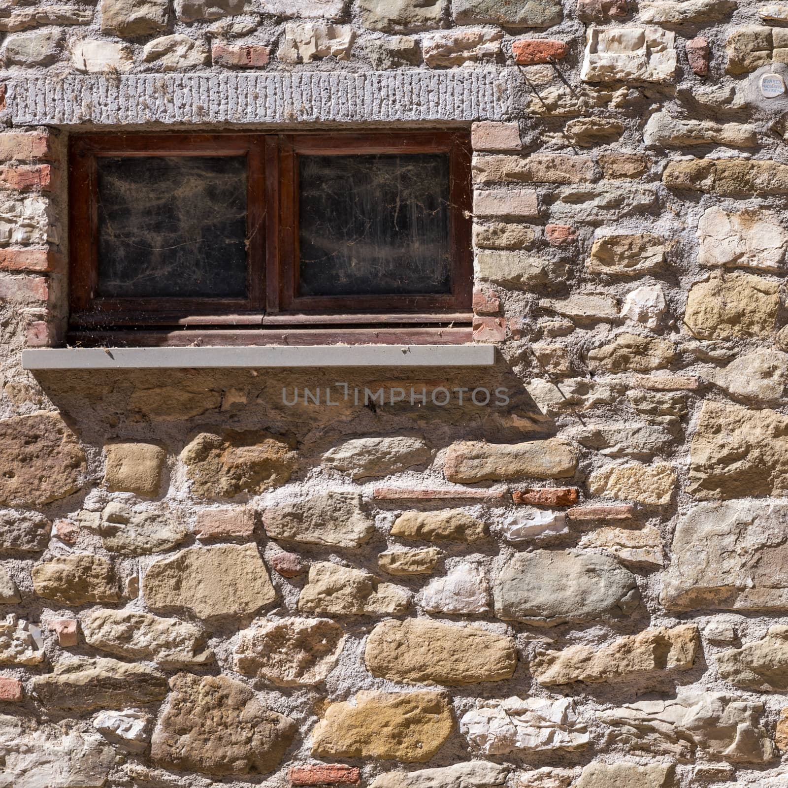 Assisi (Italy): Window on medieval stone wall