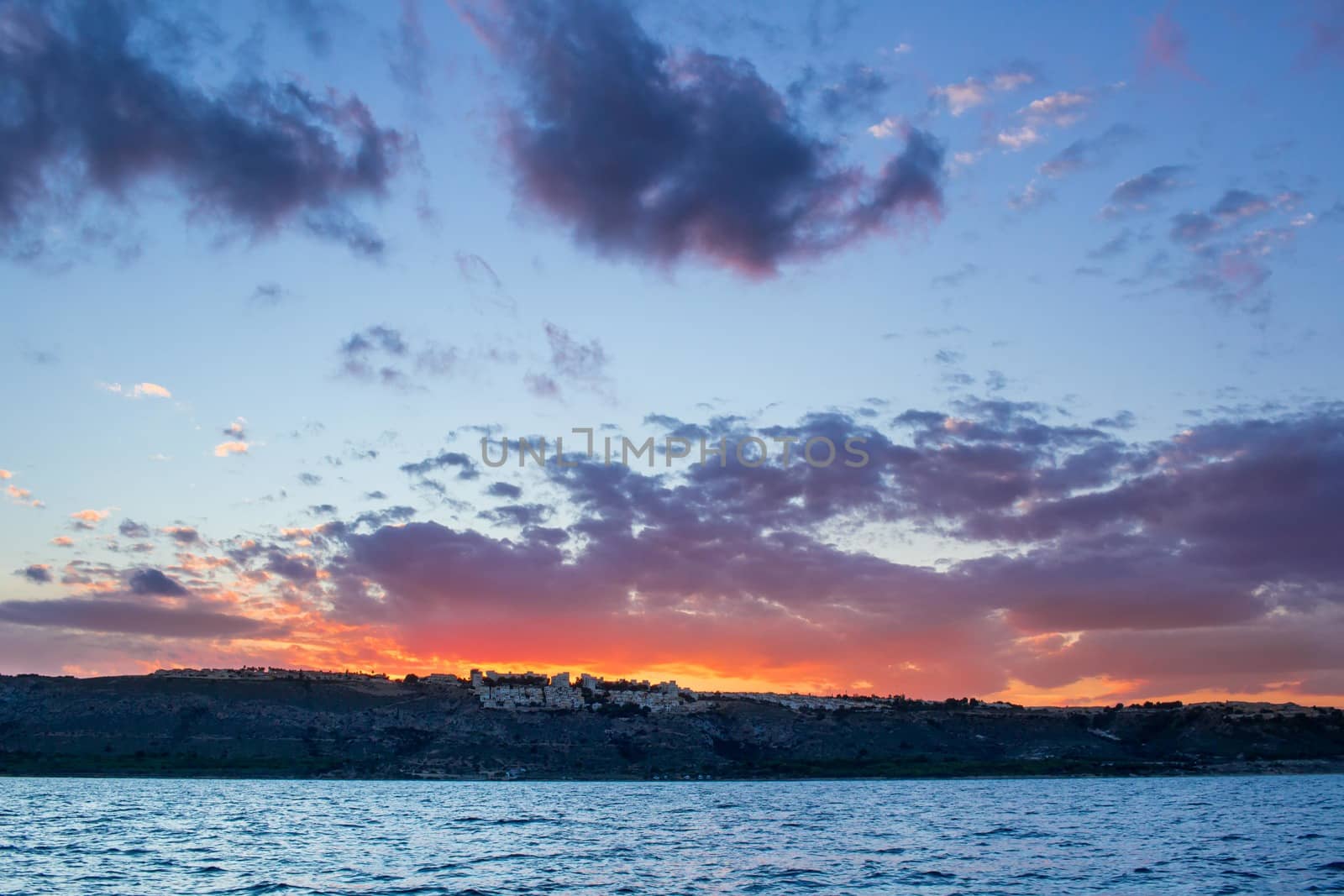 Sunset sunrise in open sea with dramatic cloudy calm clear sky