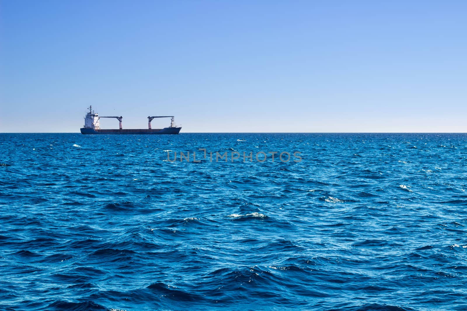 Open sea view on sunny day to longly ship