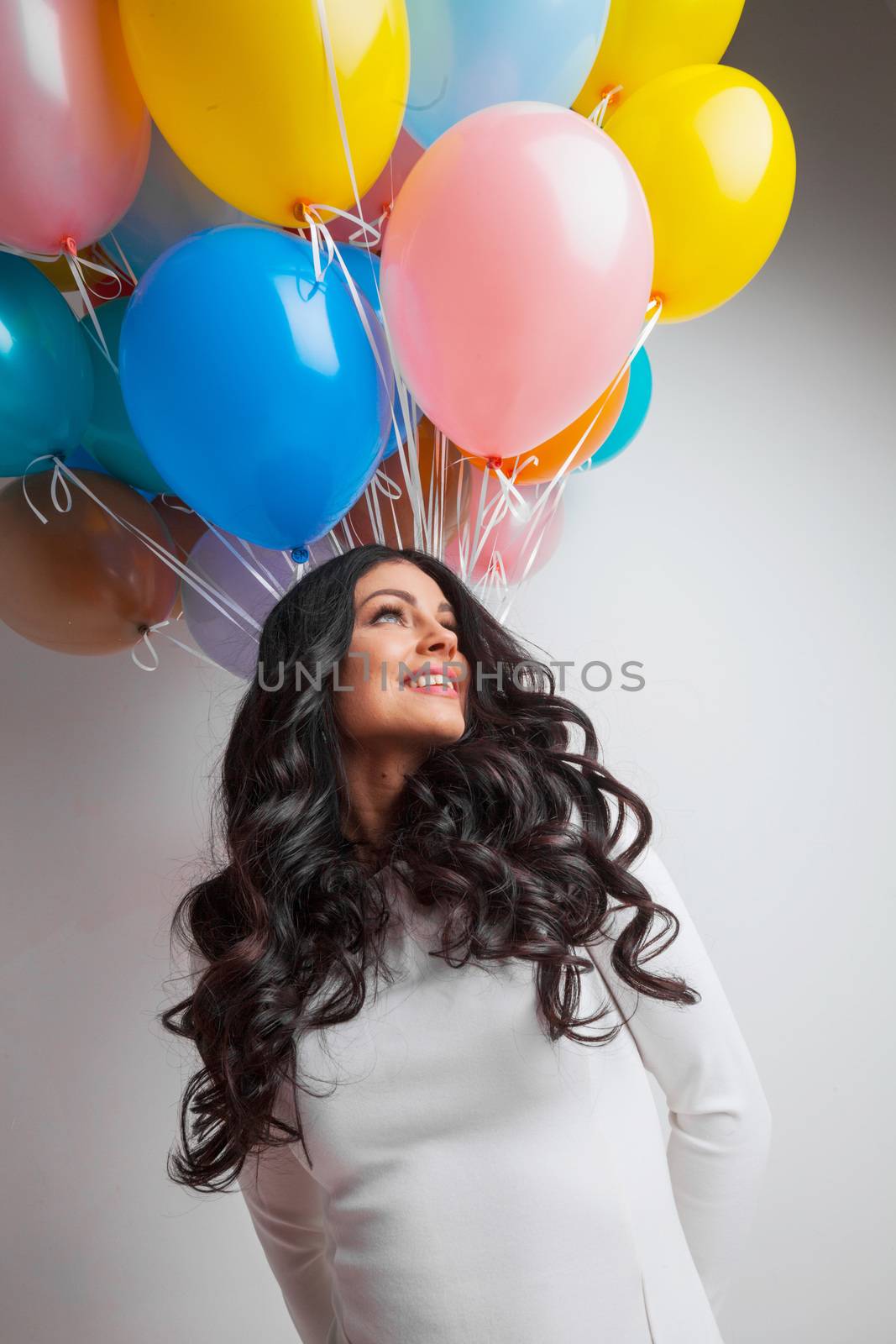 Cheerful woman holding many colorful balloons, celebration and happiness concept