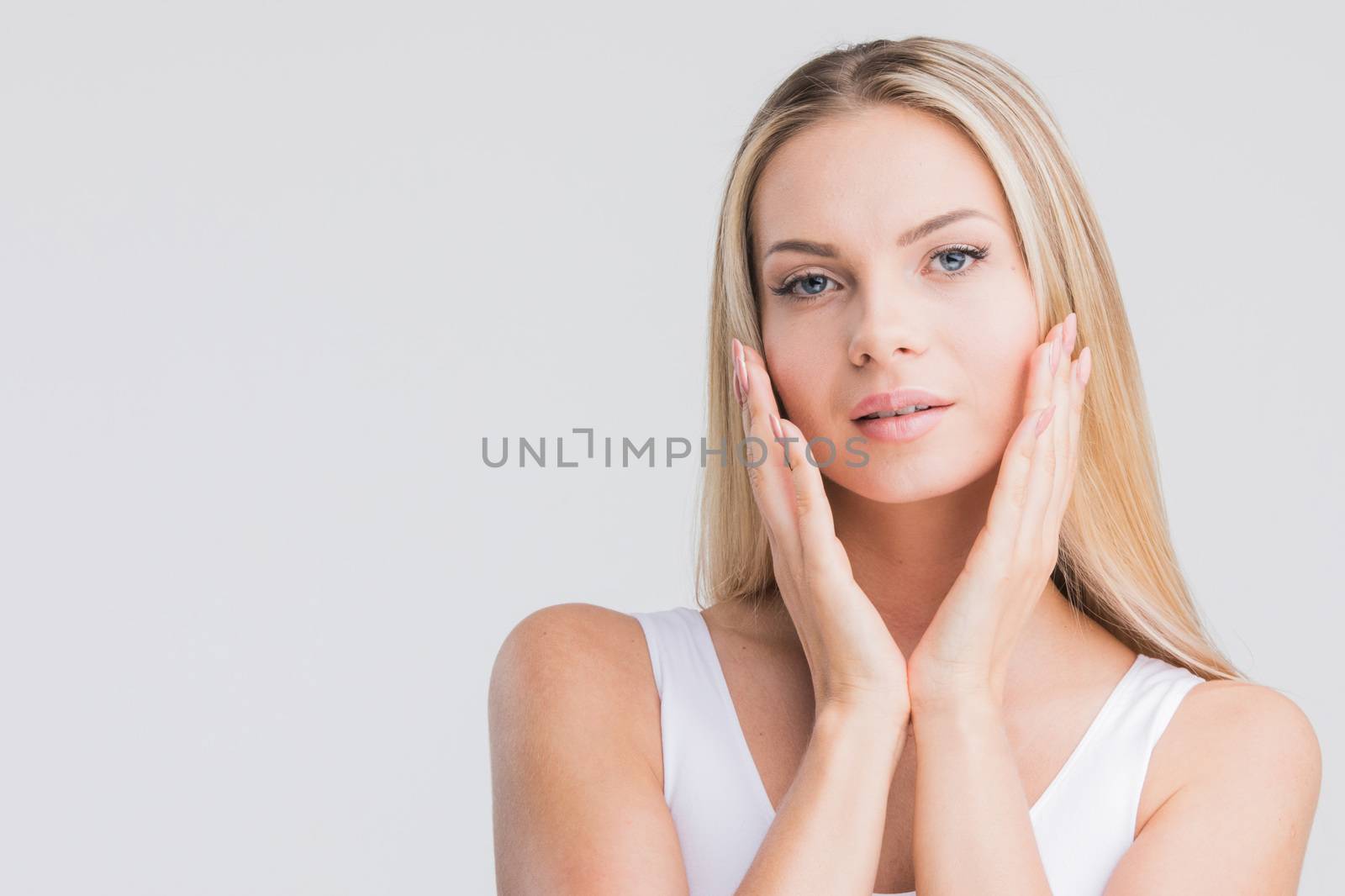 Beautiful young woman with clean fresh skin portrait on gray background with copy space