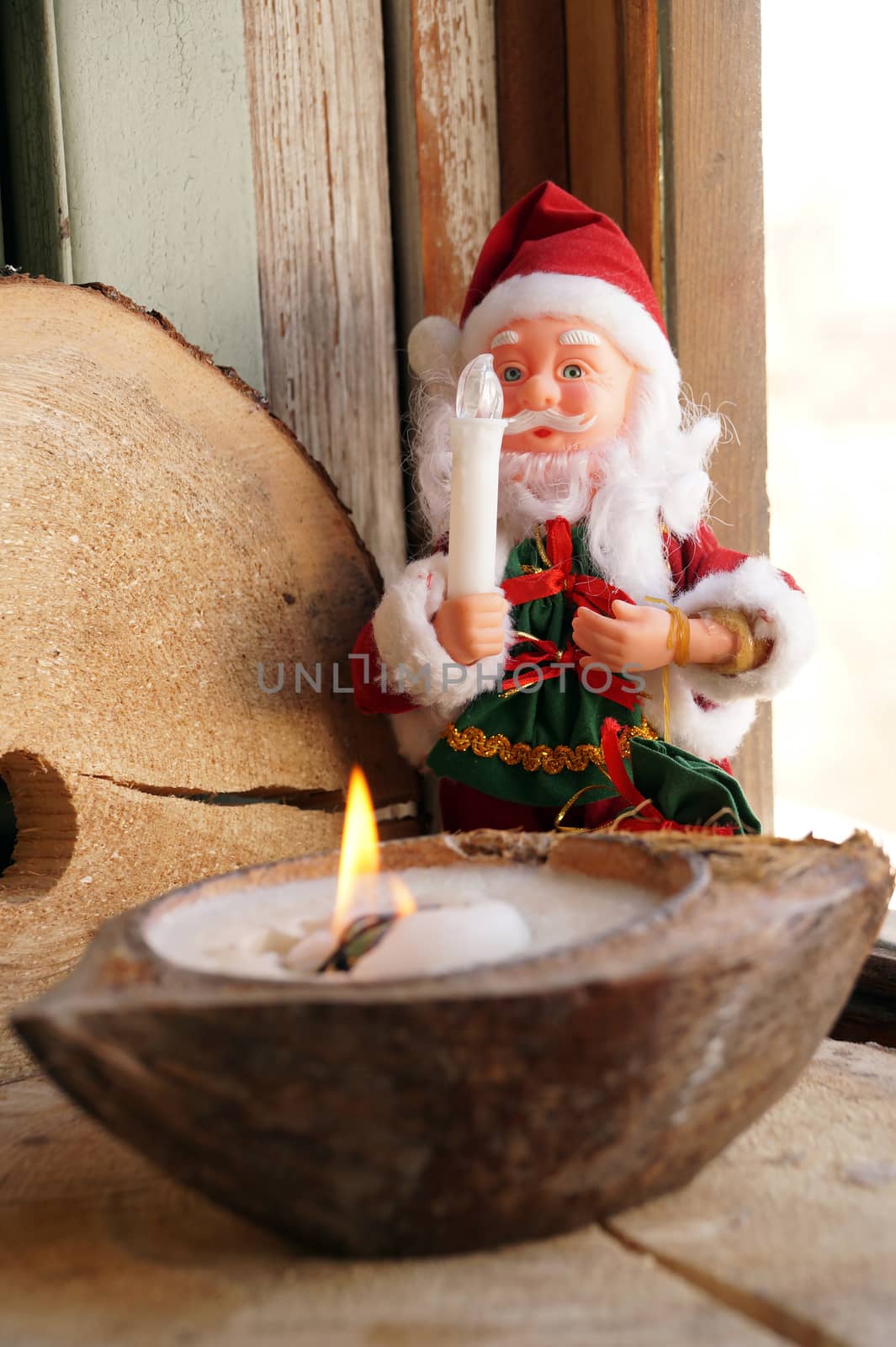 Santa Claus and a candle in a decorative coconut