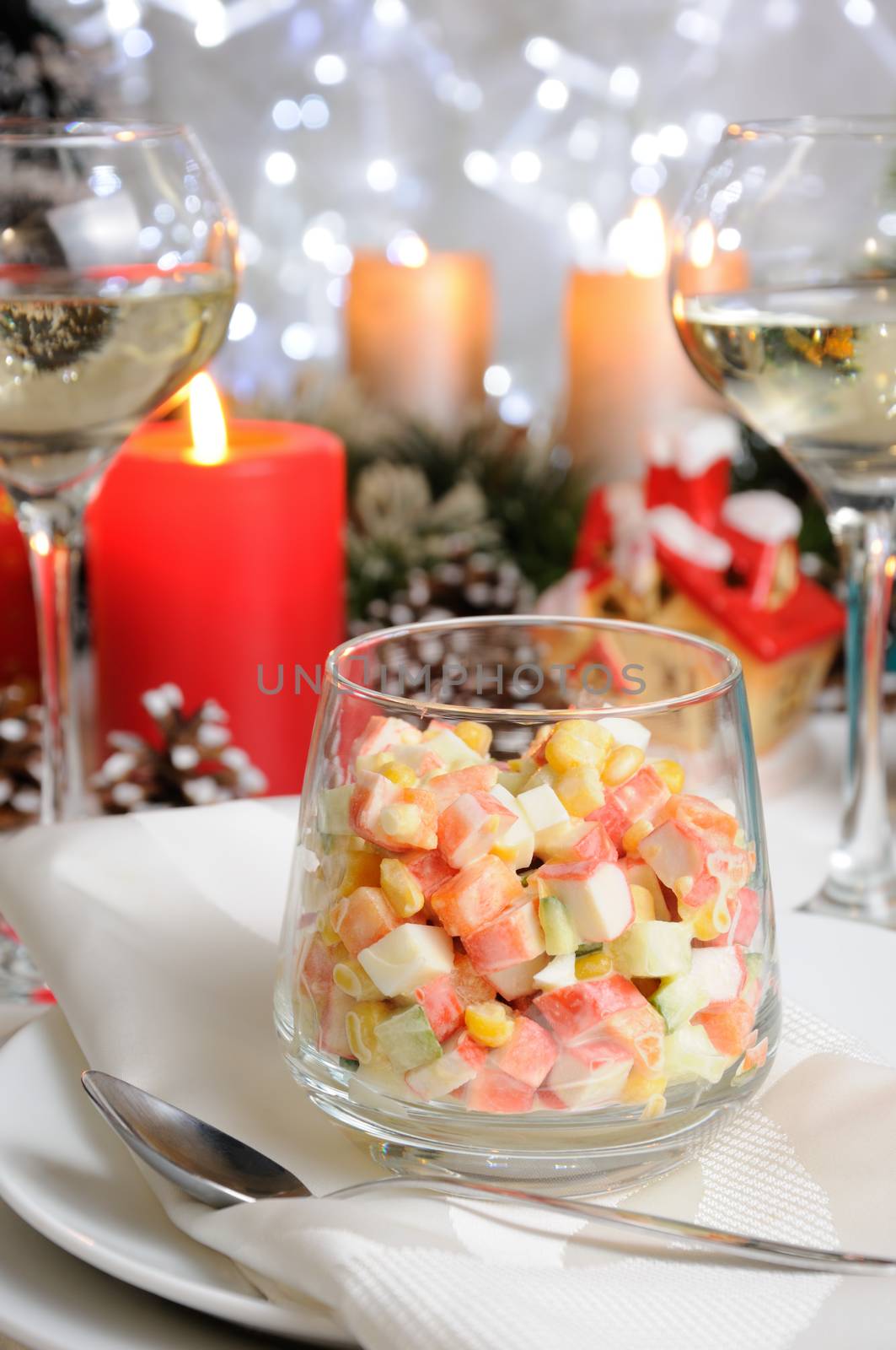 Salad of cubes of crab meat and vegetables dressed with yogurt in a glass on the Christmas table