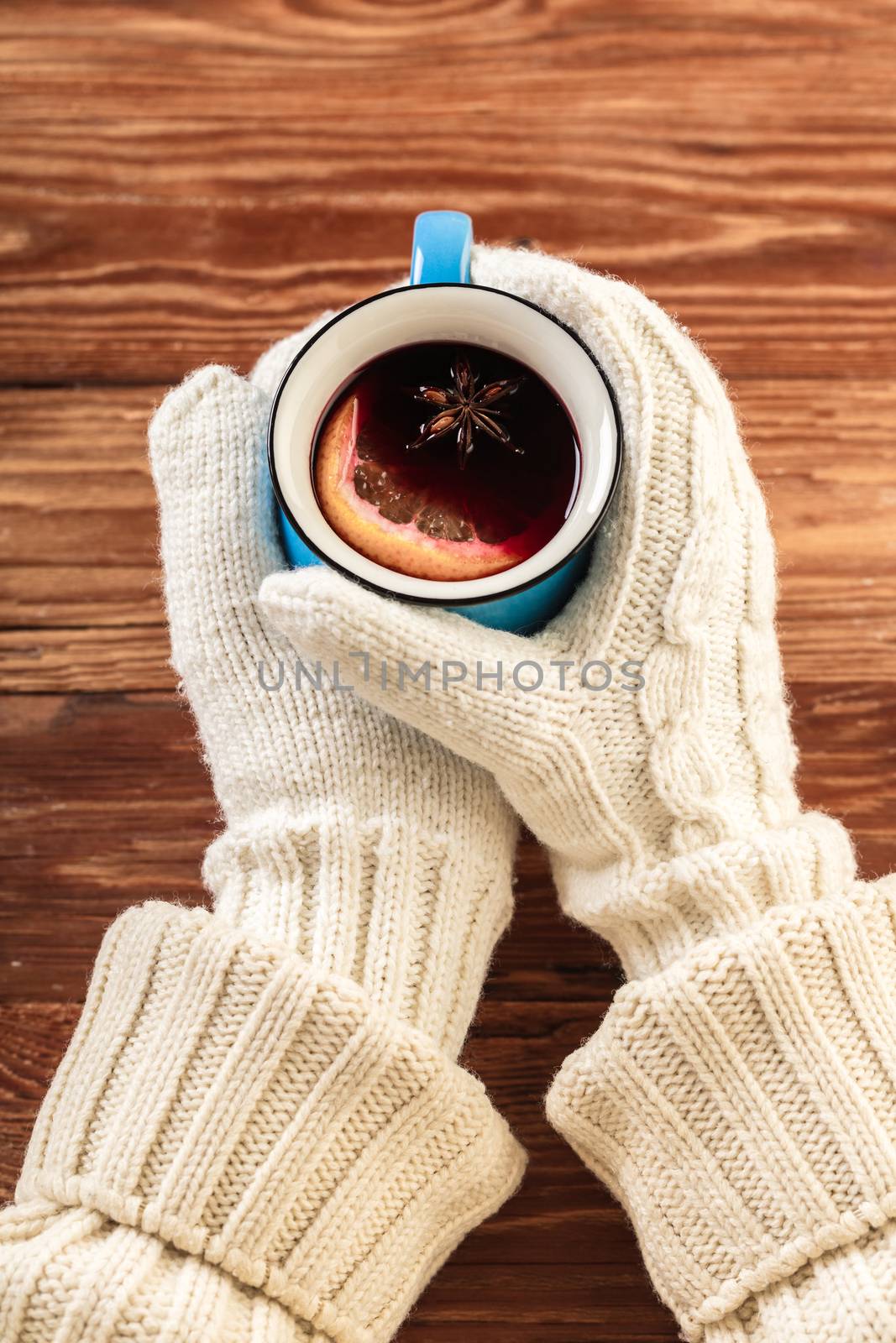 female hands in gloves holding mulled wine