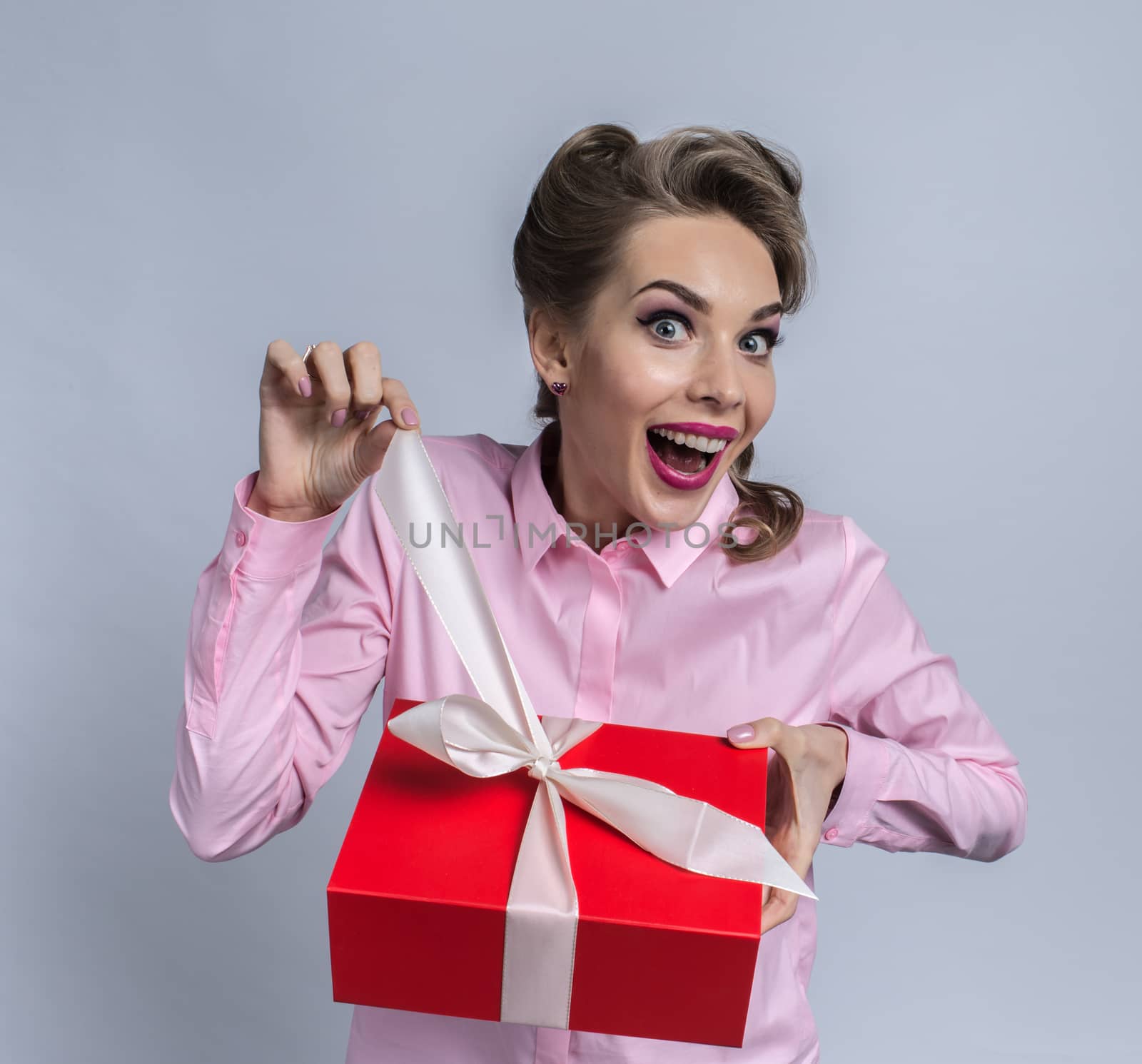 Happy beautiful funny woman unpacks gift