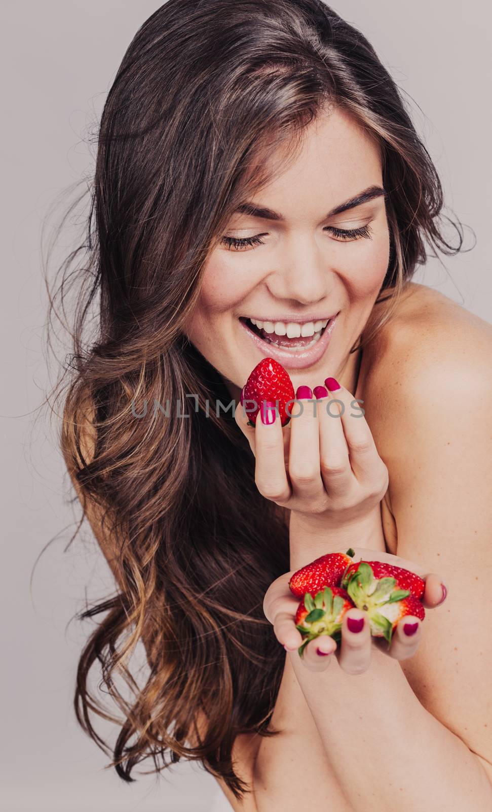 Young girl eating strawberry by ALotOfPeople